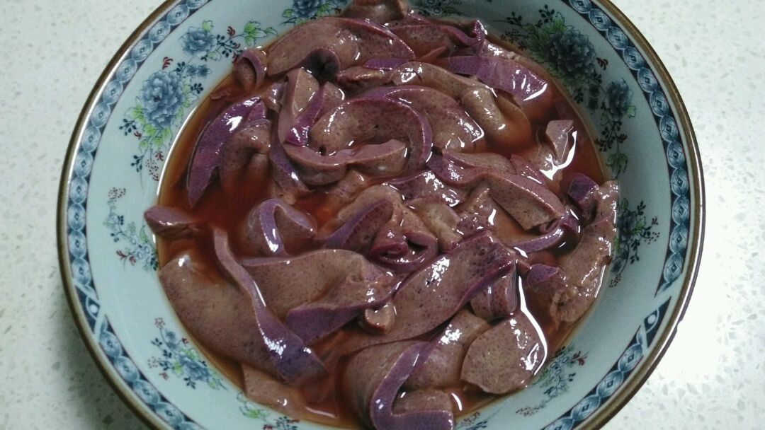 猪肝切片后,用清水洗净里面的血,用料酒腌制,备用.