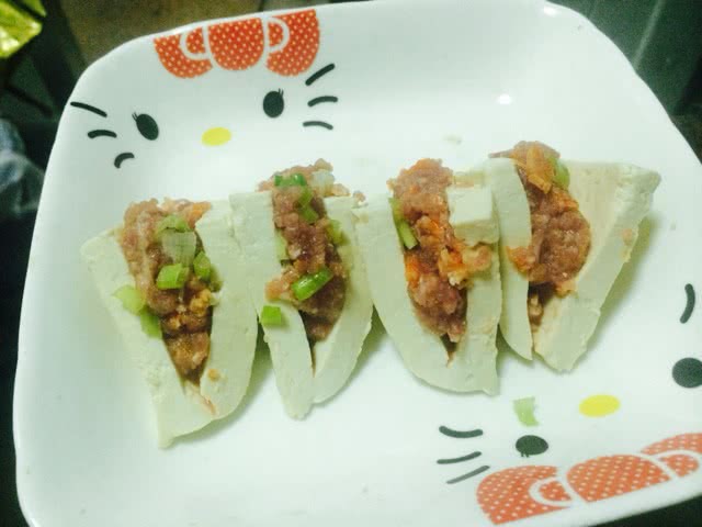 取刚刚弄好的肉馅放入小三角豆腐.