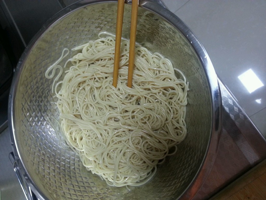 清水煮开下挂面,煮熟后捞出放入凉白开中冷却滤干,稍放点豆油搅拌