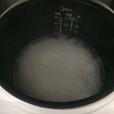 用米杯量2杯大米,洗干净后,按电饭煲刻度加入水,稍多一点点水,盖上按