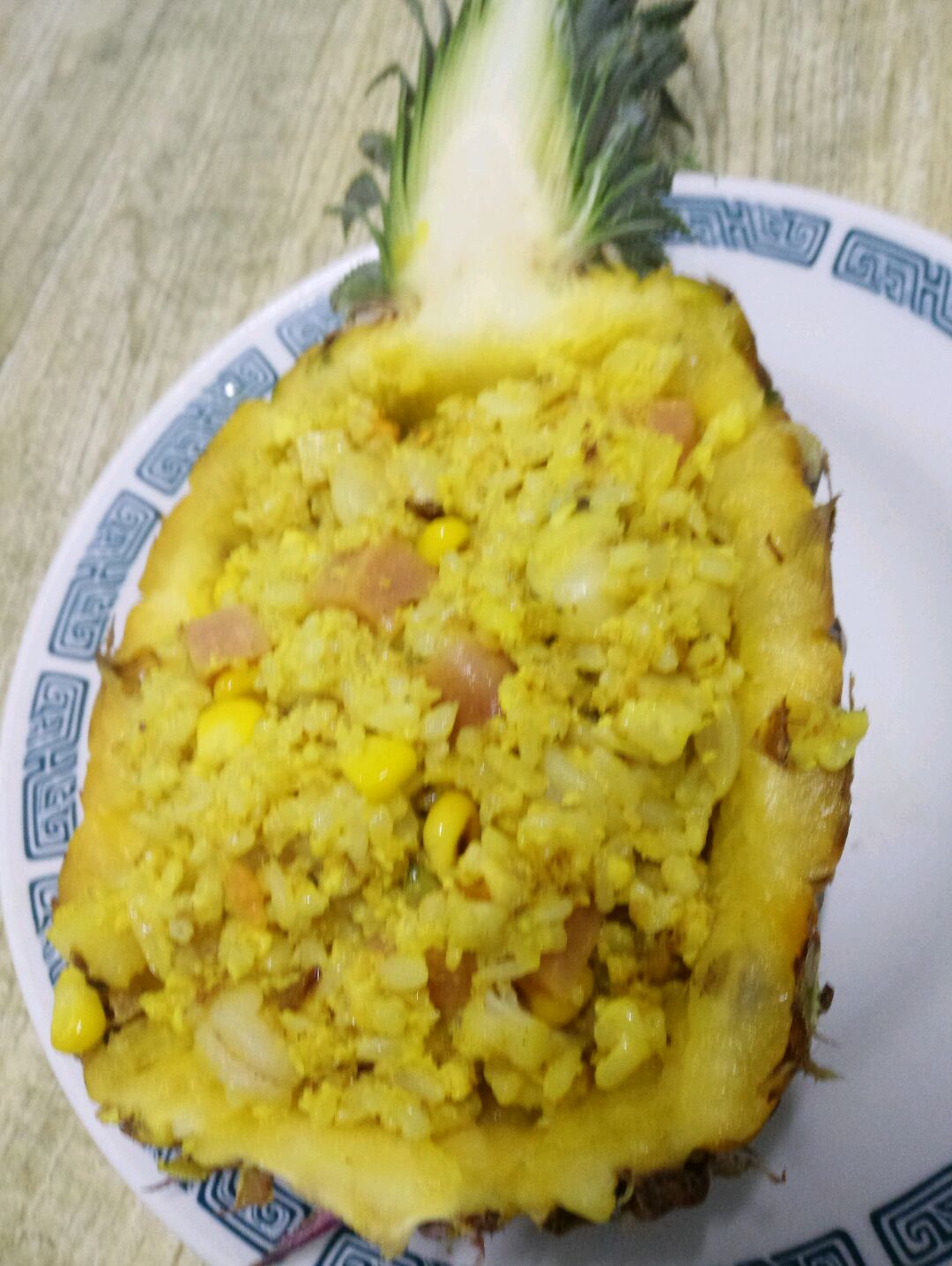 10. 锅中放油,洋葱,烧出葱香后放黄油,融化后放入米饭,米饭炒到米粒分离后,依次放入,菠萝丁,菠萝丁用量一个人口味,如果一个人饭量建议放3分之1菠萝丁,放入后用铲子压一下,压出汤汁,与米饭搅匀,在放入虾仁,扇贝,蟹棒,火腿,玉米粒,盐,鸡精,进行翻炒后撒入两小勺或三勺咖喱,炒至米饭变色后,立即盛到菠萝里盖上芝士,撒上黑胡椒,盖上个盘子让芝士融化