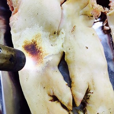 1.猪蹄用火枪烧干净毛,同时烧成焦焦的效果更香