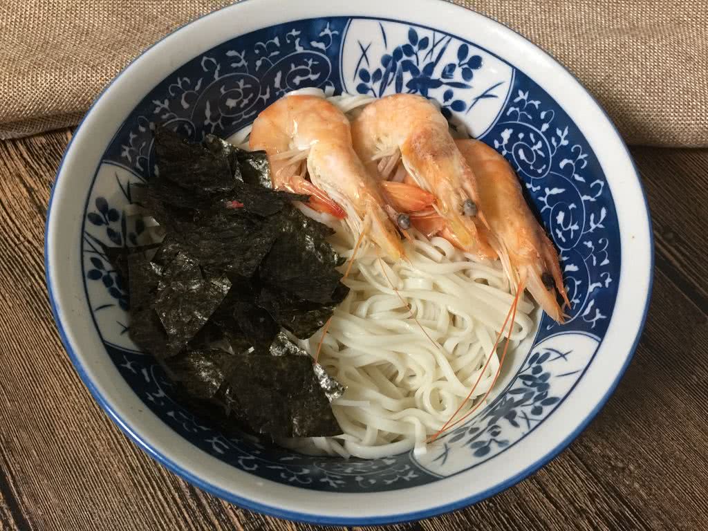 煮好的面条和大虾捞出摆盘备用,同时放上紫菜碎.