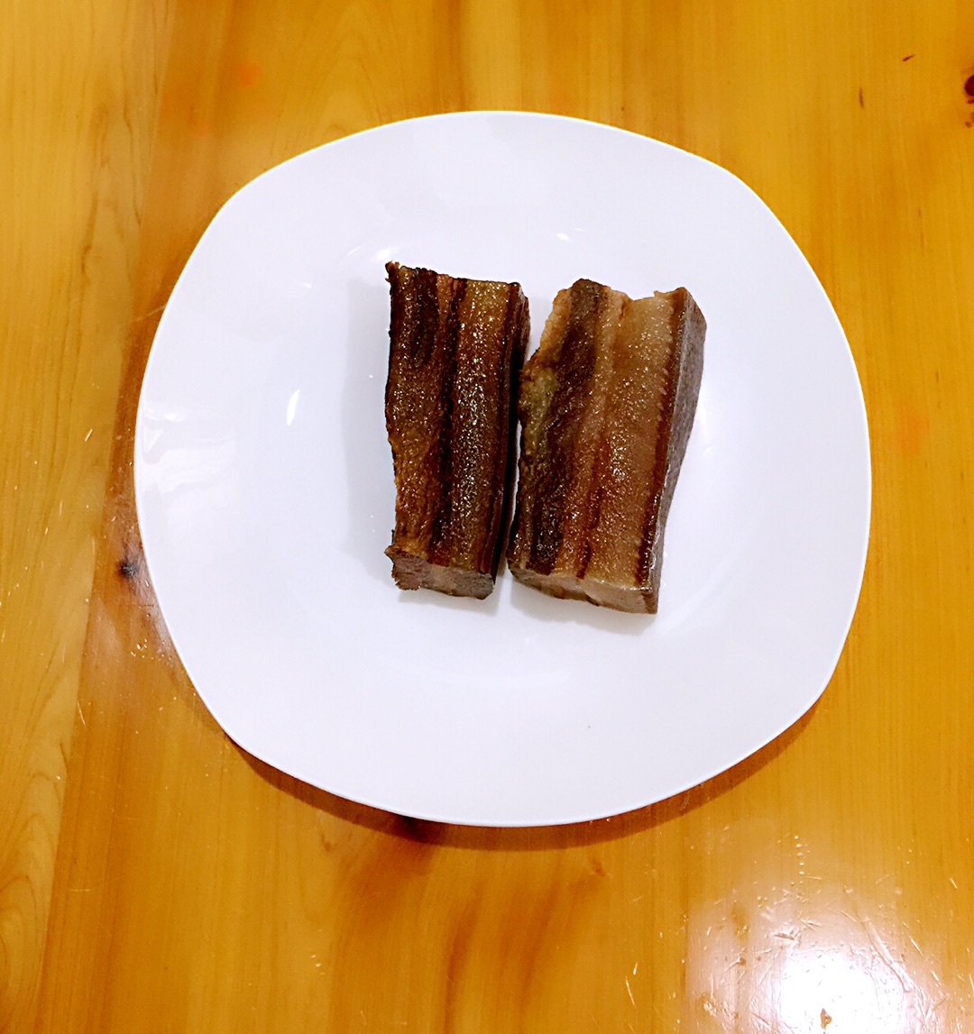 将腊肉入温水中浸泡清洗后放入锅中加水煮20分钟,取出切薄片.