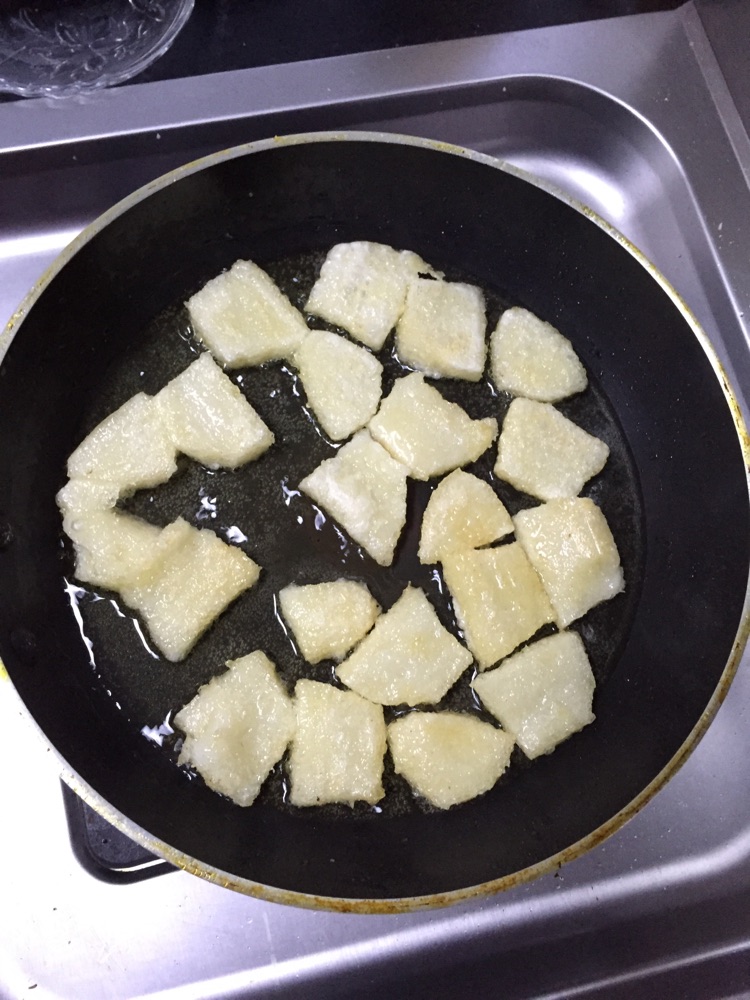 起油锅,等油温上来放入年糕,炸至两面金,年糕起锅,倒出多余的油