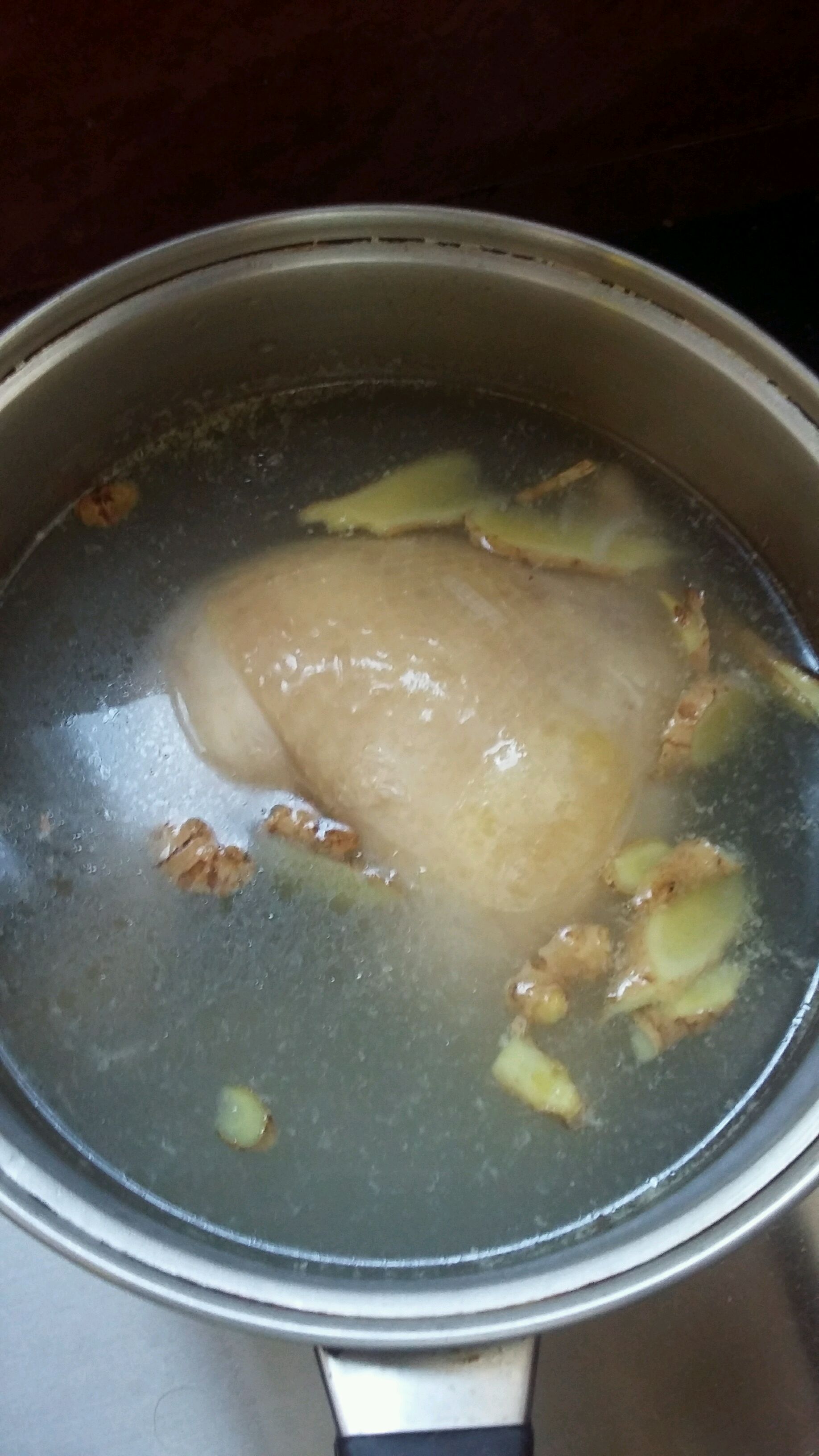 放姜片,米酒,蒜片煮鸡肉.