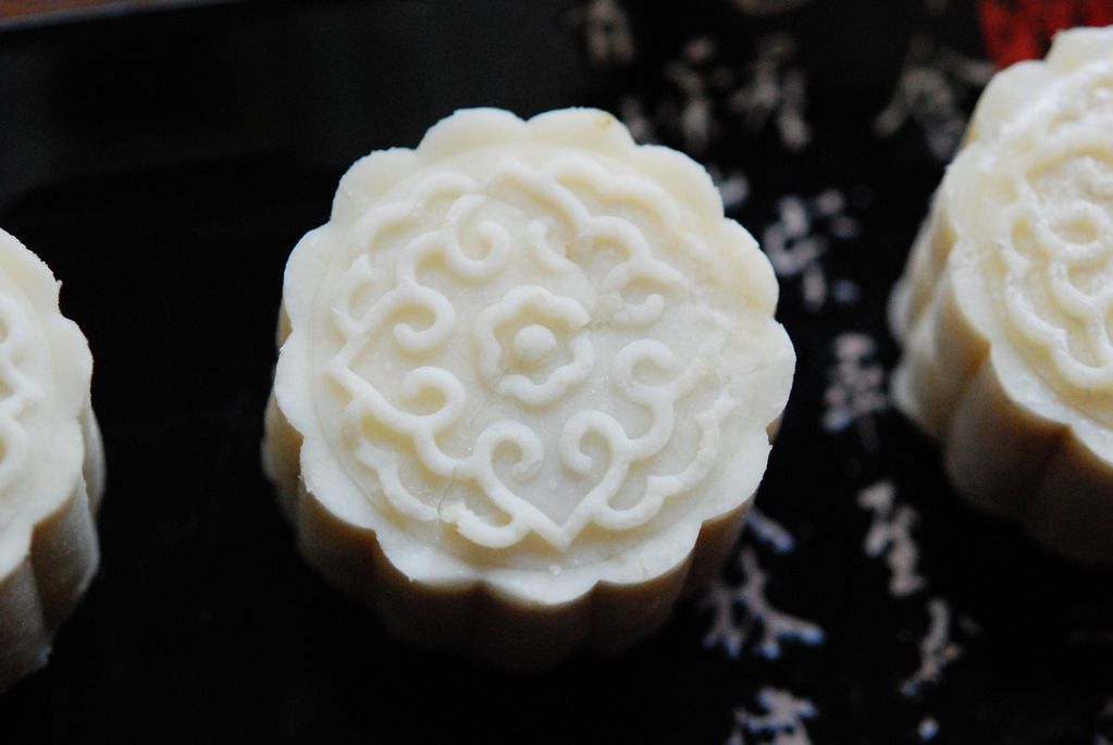 3. 煮好的红枣(红枣只需煮20多分钟就熟了)第一步取出山药的同时,红枣也取出晾凉,剥皮去核,用到剁碎成枣泥,然后分成六等份,团成枣泥丸子。蒸好的山药面团也揉匀,分六等份,也团成团。把山药丸子压扁,包入枣泥丸子,团成团,撒上少许手粉,用月饼模具压出冰皮月饼的样子。