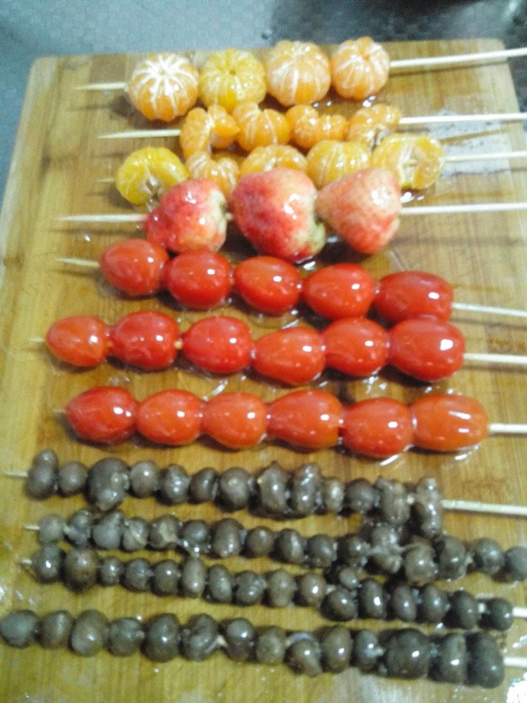 冰糖葫芦做法一   1,材料:草莓,番茄,猕猴桃,冰糖,竹签.