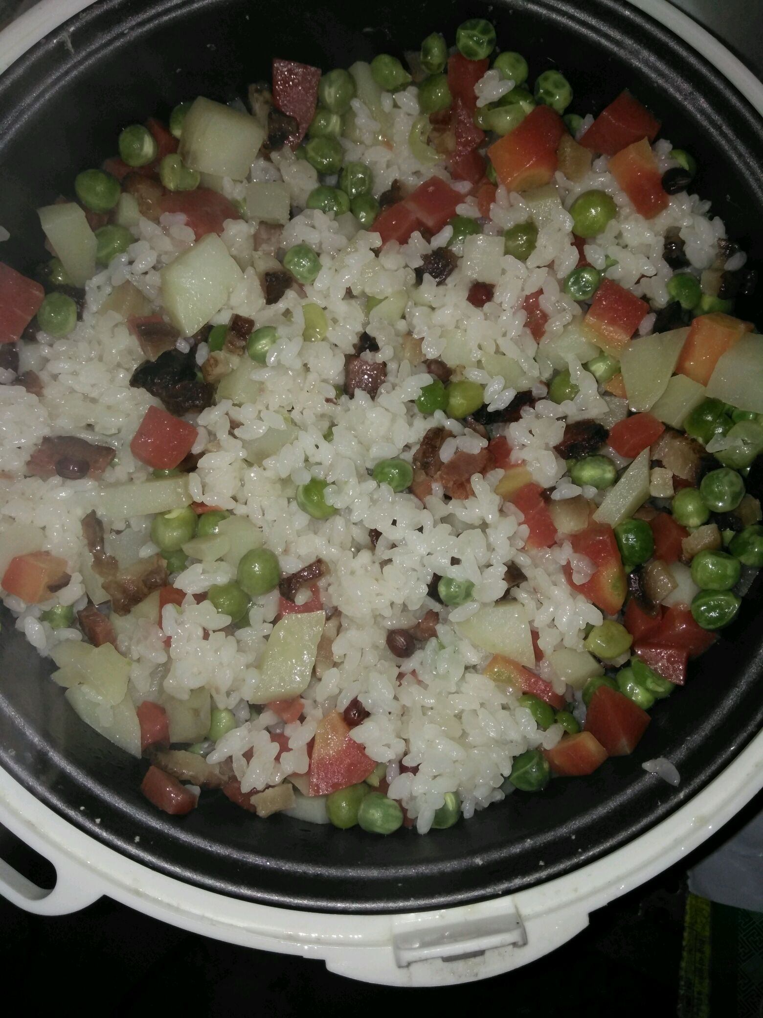 电饭锅里加入洗干净的大米糯米,加入适量水,把炒好的菜,腊肉倒入