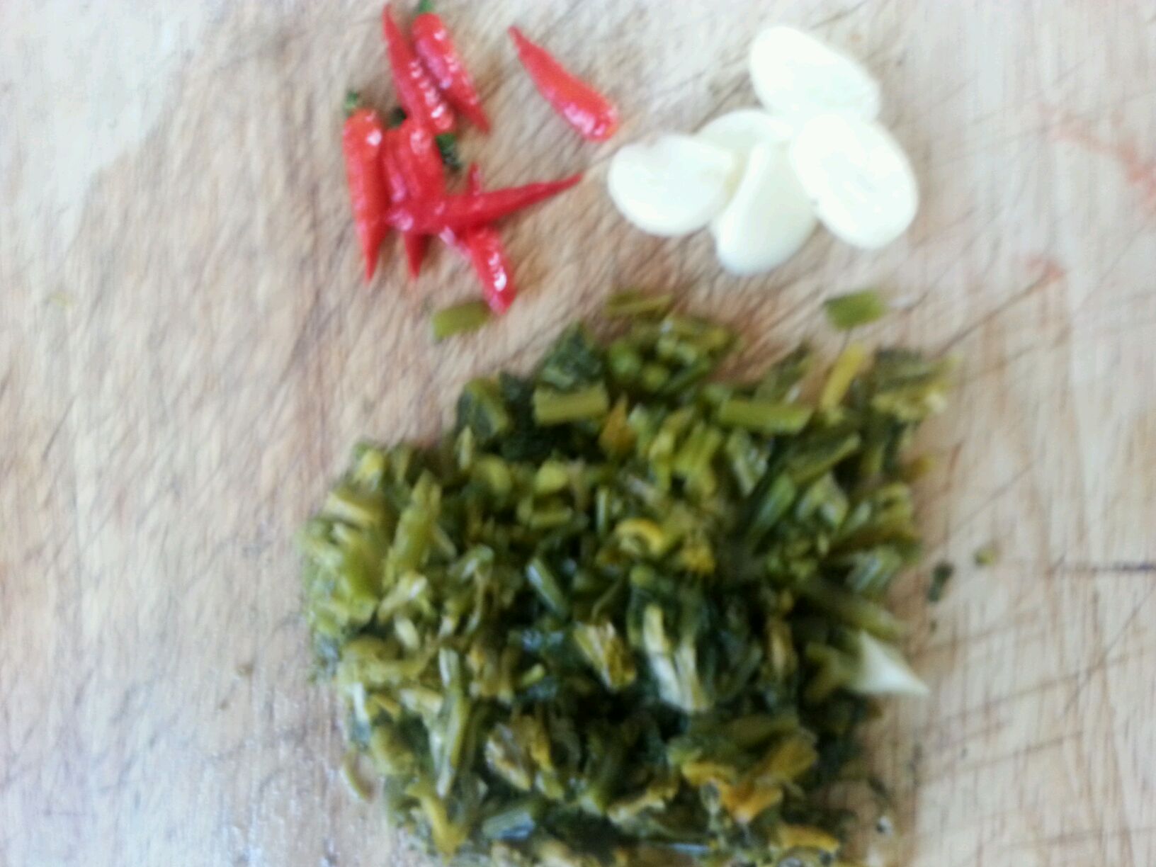 腌雪菜冼净后挤干水份切成小段,蒜切片.