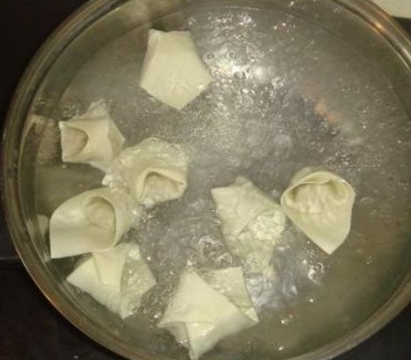 煮馄饨:水煮开后把馄饨下入锅中,用勺子沿着锅沿轻轻推动,以防馄饨